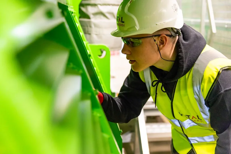 Professionnel portant un casque et inspectant un équipement industriel