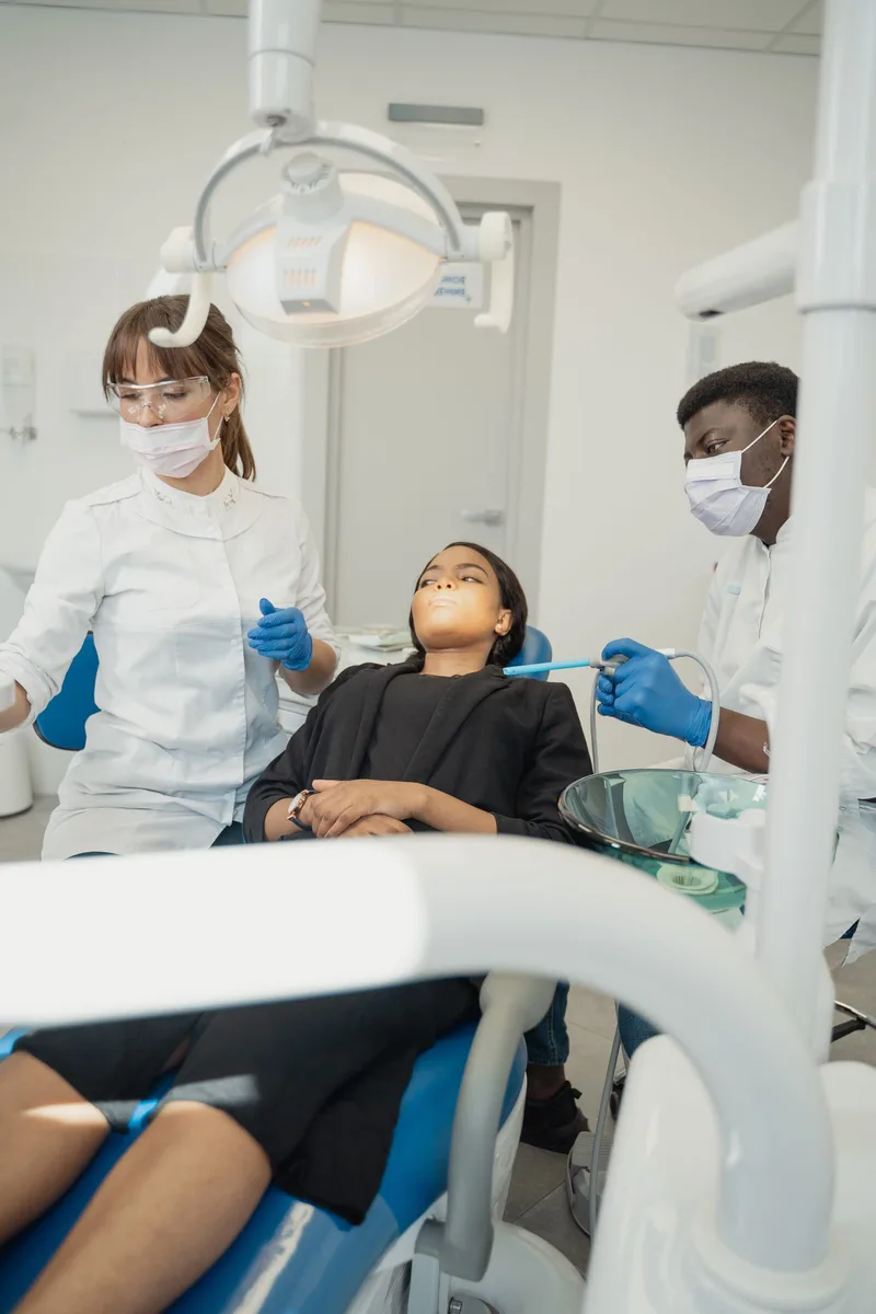 Patiente accompagnée par 2 professionnels dans un cabinet dentaire