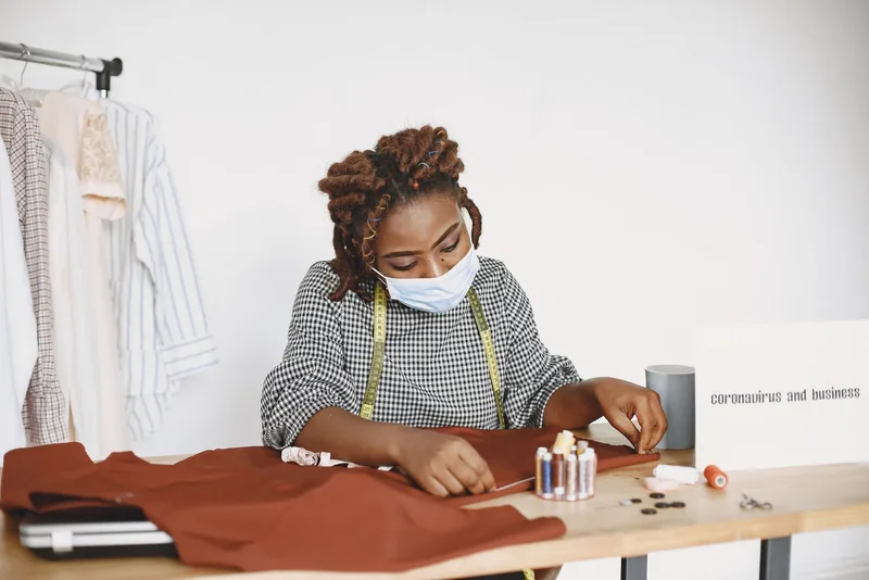 Couturière portant un masque et travaillant dans son atelier