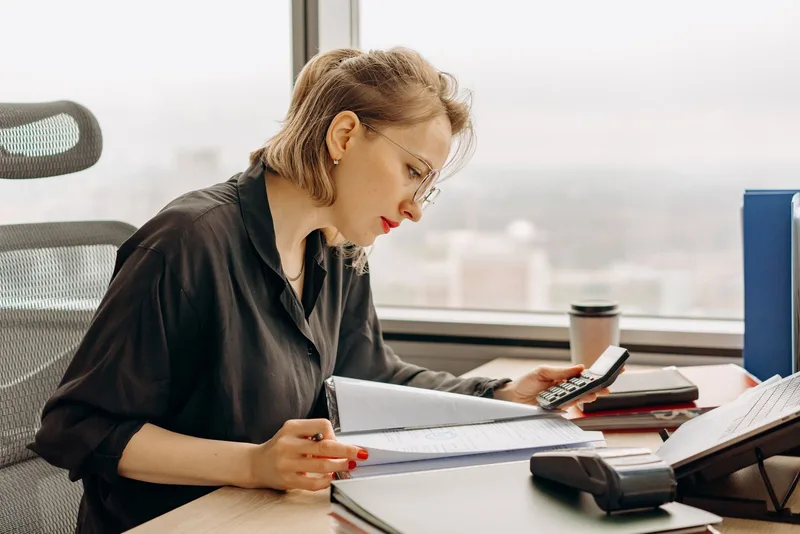 Professionnelle prenant des notes à côté d’une calculatrice